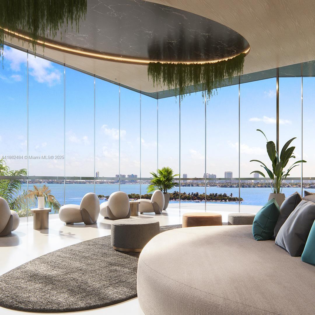 This rendering shows a modern lounge with floor-to-ceiling windows overlooking a bay and city skyline — 700 NE 24th Street, Miami FL 33137, MIAMI, FL