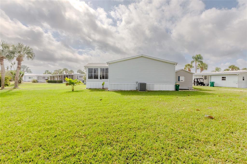 A view of the exterior of a light-colored mobile home with a grassy yard — 2100 KINGS HIGHWAY UNIT 376, PORT CHARLOTTE, FL