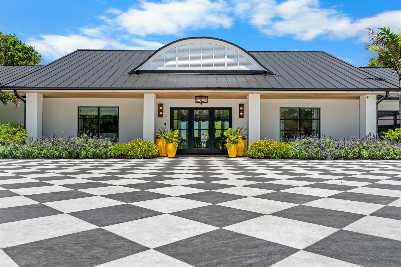 A single-story building with a black metal roof and a checkered patio entrance — VERO BEACH, FL