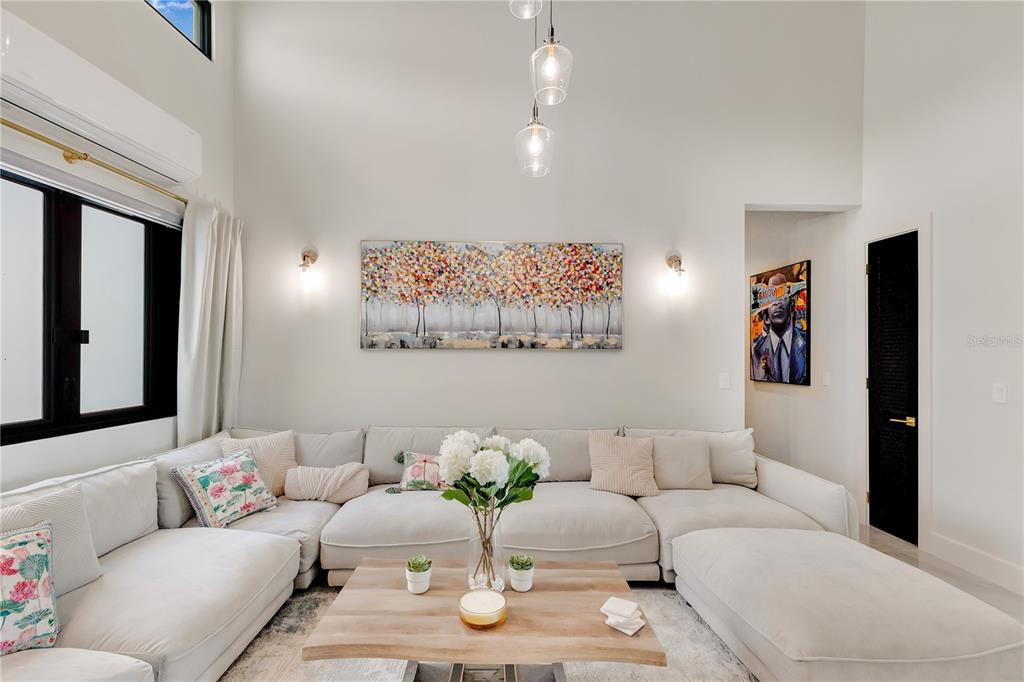 A living room features a large sectional sofa, a wooden coffee table, and high ceilings — 6000 RIO MAR BOULEVARD UNIT 7131, RIO GRANDE, PR