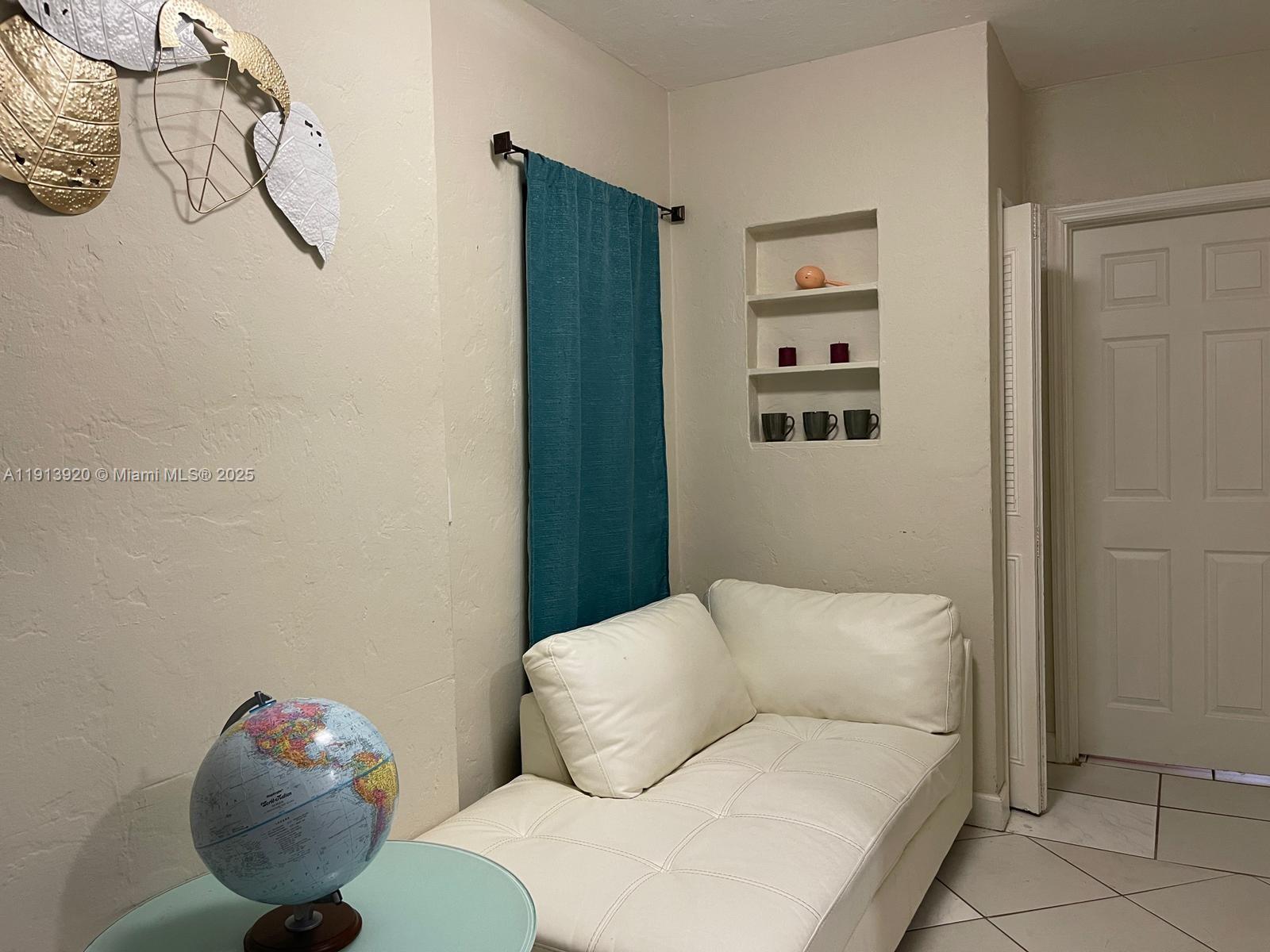 A room features a white chaise lounge, a globe on a table, and wall niches — 55 NW 69th St, Miami FL 33150, MIAMI, FL