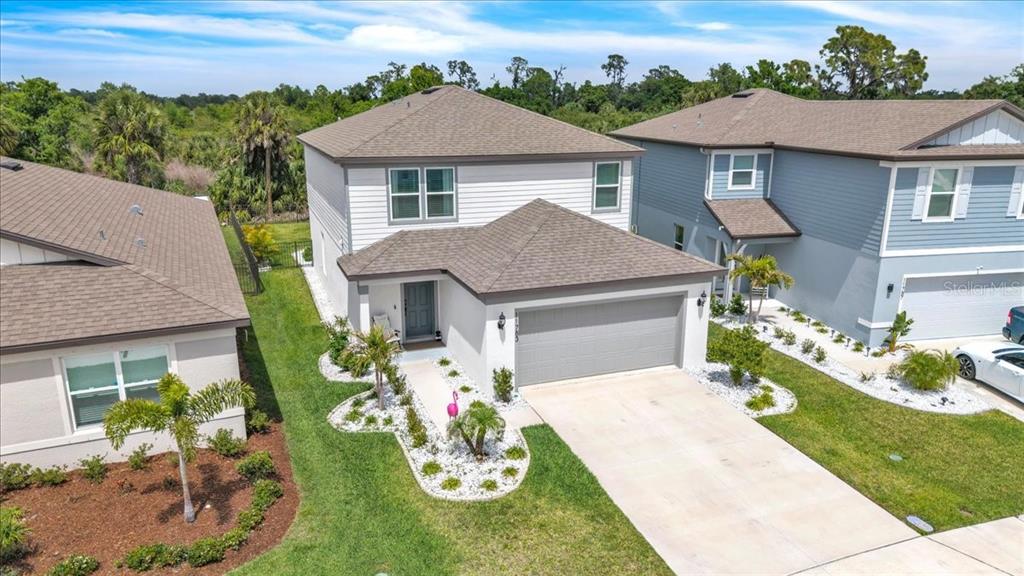 An aerial view of a two-story suburban house with a gray garage and landscaping — 11783 MOONSAIL DRIVE, PARRISH, FL