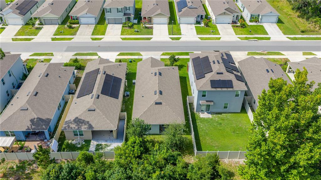 An aerial view shows several suburban houses with shingled roofs and solar panels — 1745 BENT BRANCH AVENUE, DELAND, FL