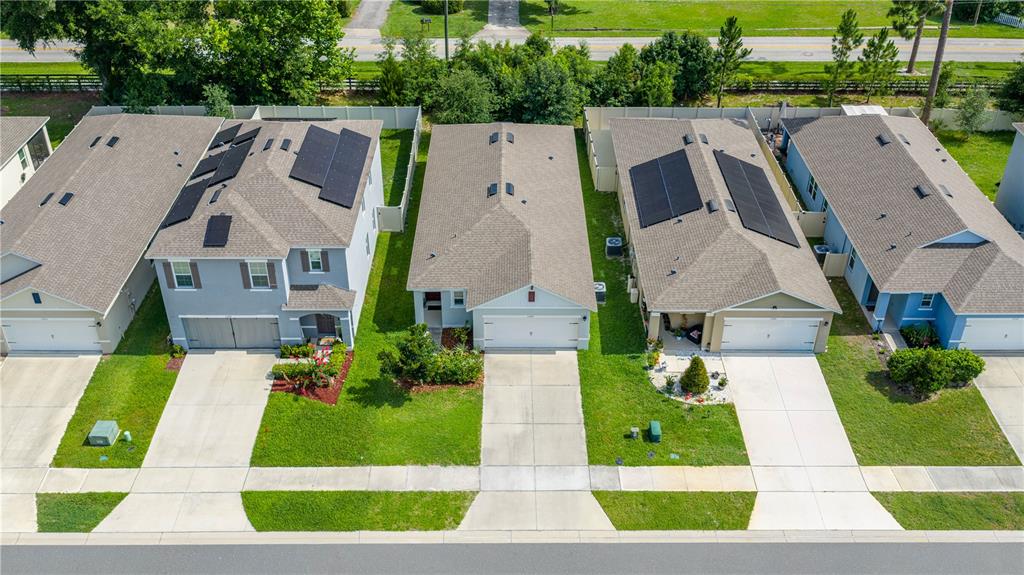 An aerial view shows four suburban houses with driveways and lawns along a street — 1745 BENT BRANCH AVENUE, DELAND, FL