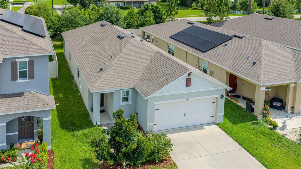 An aerial view shows a light-colored single-story house with a garage and shingled roof — 1745 BENT BRANCH AVENUE, DELAND, FL