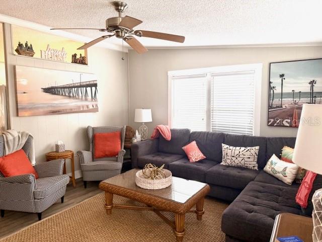 A living room features a dark sectional sofa, a patterned armchair, and a coffee table — 15010 113TH AVENUE N UNIT 53, LARGO, FL