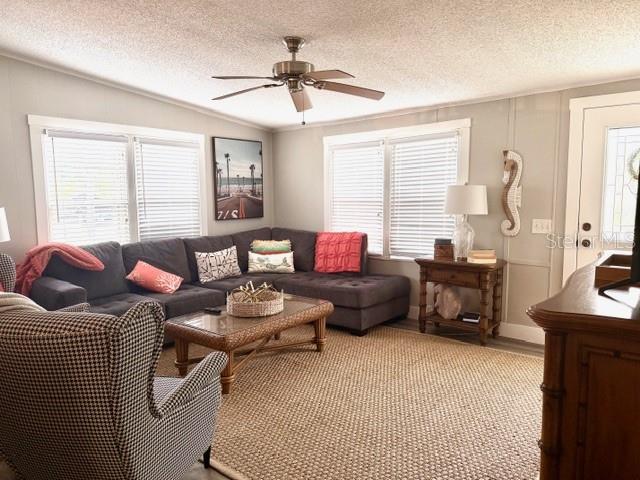 A living room features a gray sectional sofa, a wicker coffee table, and a ceiling fan — 15010 113TH AVENUE N UNIT 53, LARGO, FL