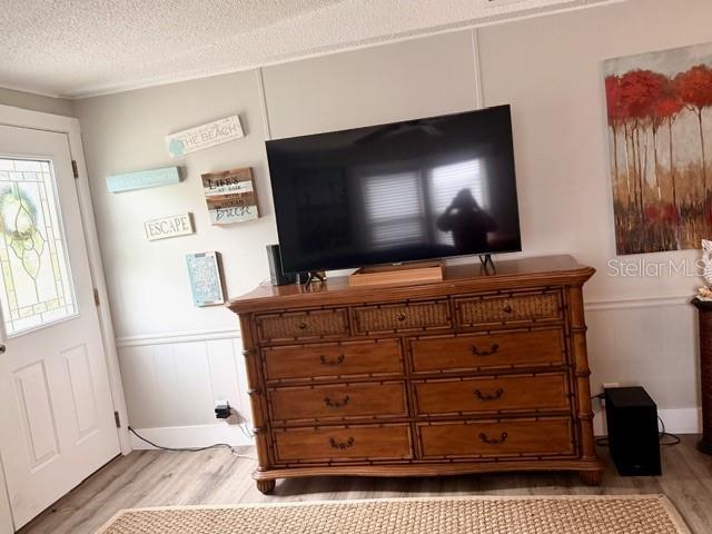 A television sits on a wooden dresser in a room with light-colored walls — 15010 113TH AVENUE N UNIT 53, LARGO, FL
