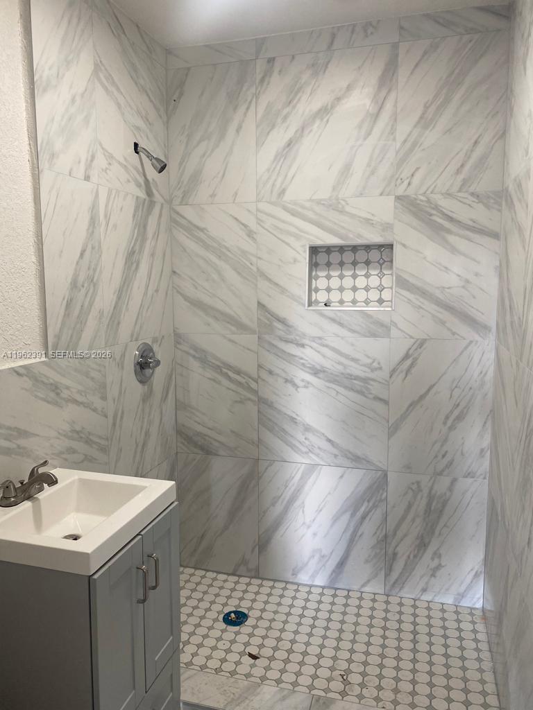 A bathroom features a walk-in shower with marble-look tile, a niche, and a gray vanity — 10030 W Indigo St # 9, Miami FL 33157, MIAMI, FL