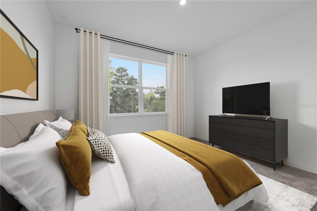 This bedroom features a bed with yellow accents, a dark dresser, and a large window — 6629 VERBENA PLACE, LAKE HAMILTON, FL