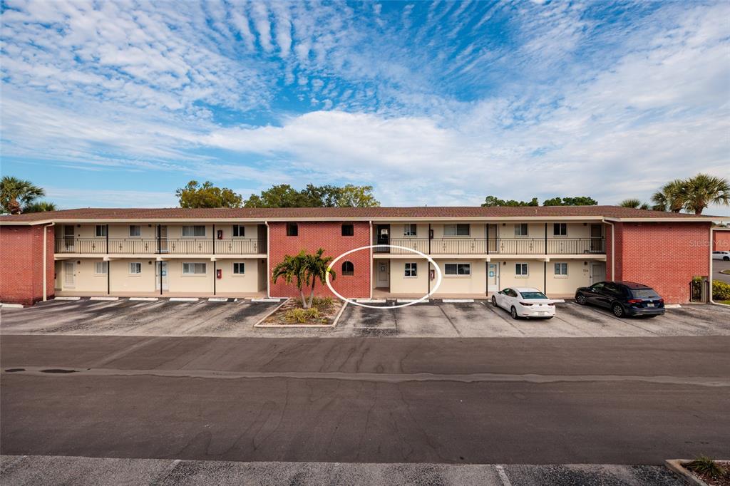 A two-story brick apartment building features a ground-level exterior walkway and a circled entrance — 4550 OVERLOOK DRIVE NE UNIT 154, ST PETERSBURG, FL