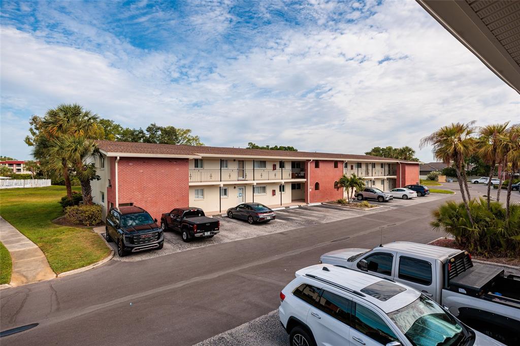 A two-story apartment building with red brick accents and a parking lot in front — 4550 OVERLOOK DRIVE NE UNIT 154, ST PETERSBURG, FL