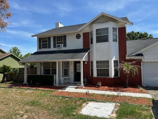 A two-story house features white siding, red brick accents, and a covered front porch — 6926 THOUSAND OAKS ROAD, ORLANDO, FL