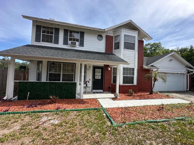 A two-story house with white siding, red brick accents, and a front porch — 6926 THOUSAND OAKS ROAD, ORLANDO, FL