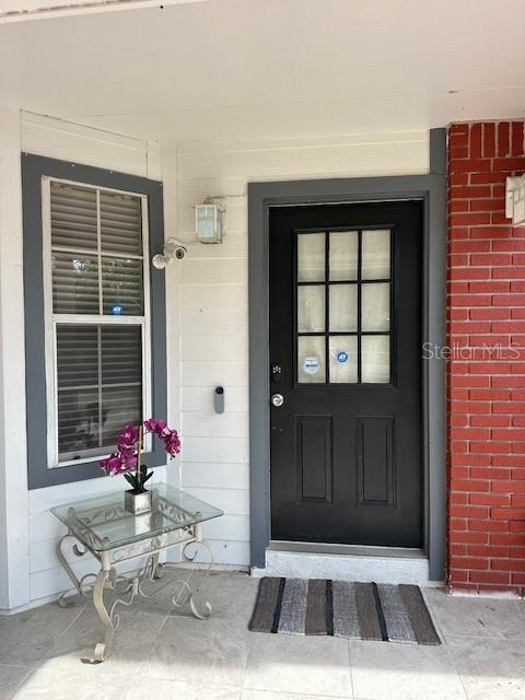 A front porch features a black door, a glass-topped side table, and a window — 6926 THOUSAND OAKS ROAD, ORLANDO, FL