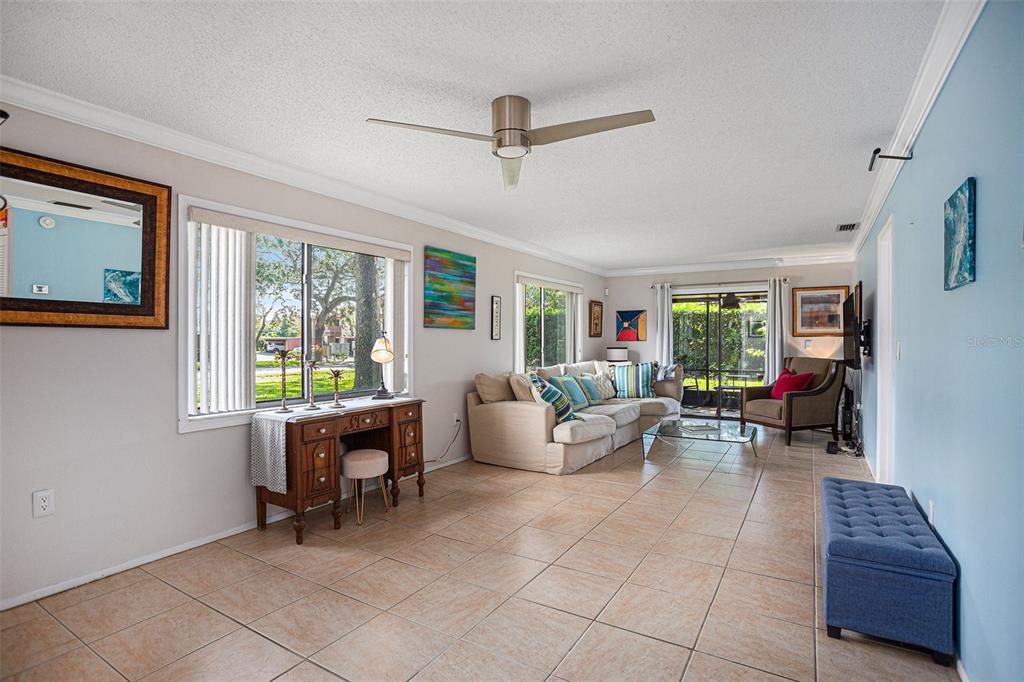 A living room with tile floors, a beige sectional sofa, and a wooden vanity table — 600 SUMMERHILL COURT UNIT A, SAFETY HARBOR, FL