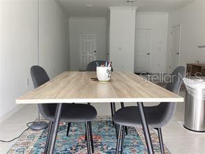 A dining area features a light wood table with four gray chairs on a patterned rug — 17522 NECTAR FLUME DRIVE, LAND O LAKES, FL