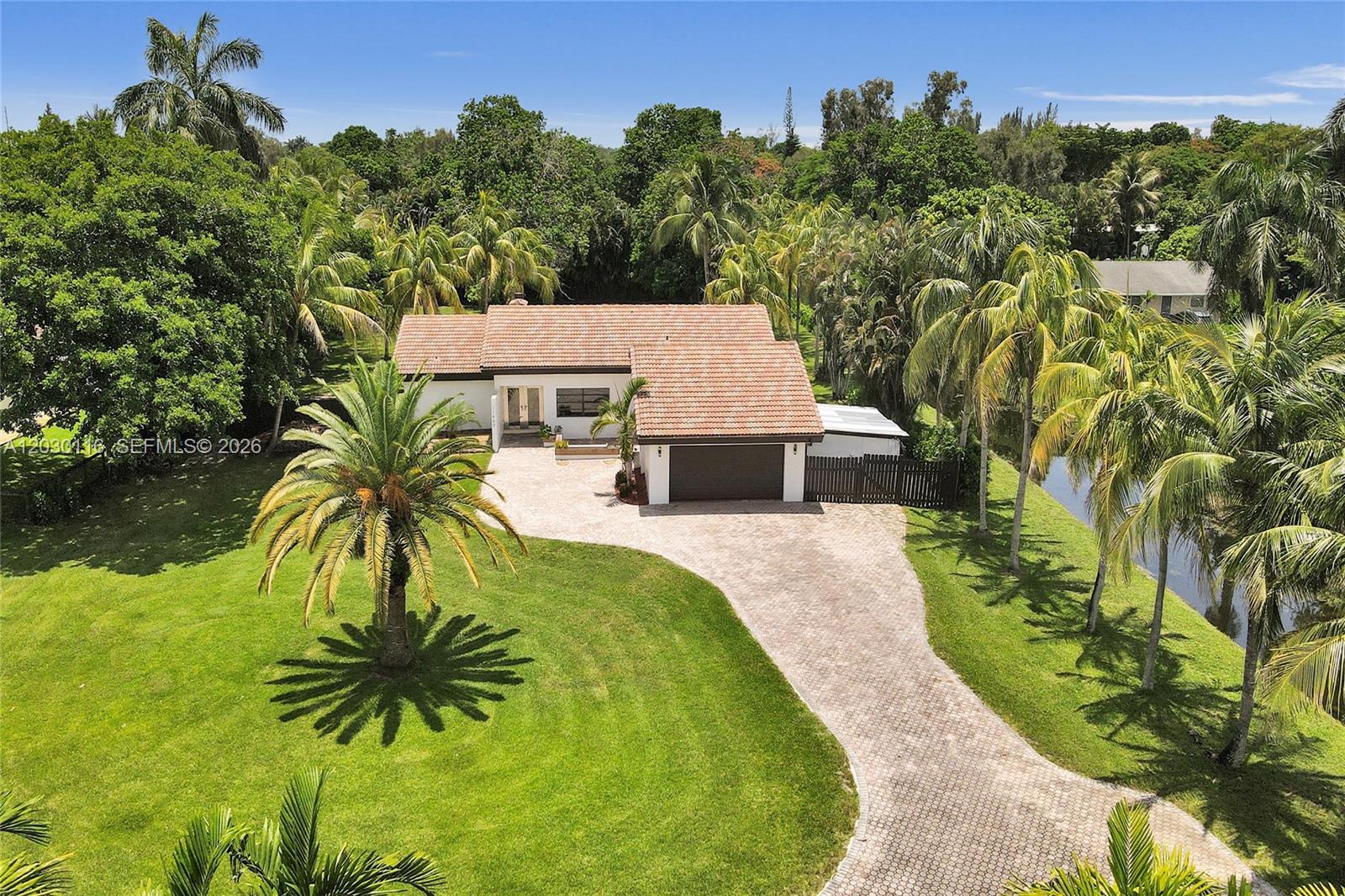 An aerial view shows a single-story house with a tiled roof and a paved driveway — 11460 SW 1st Ct, Plantation FL 33325, PLANTATION, FL