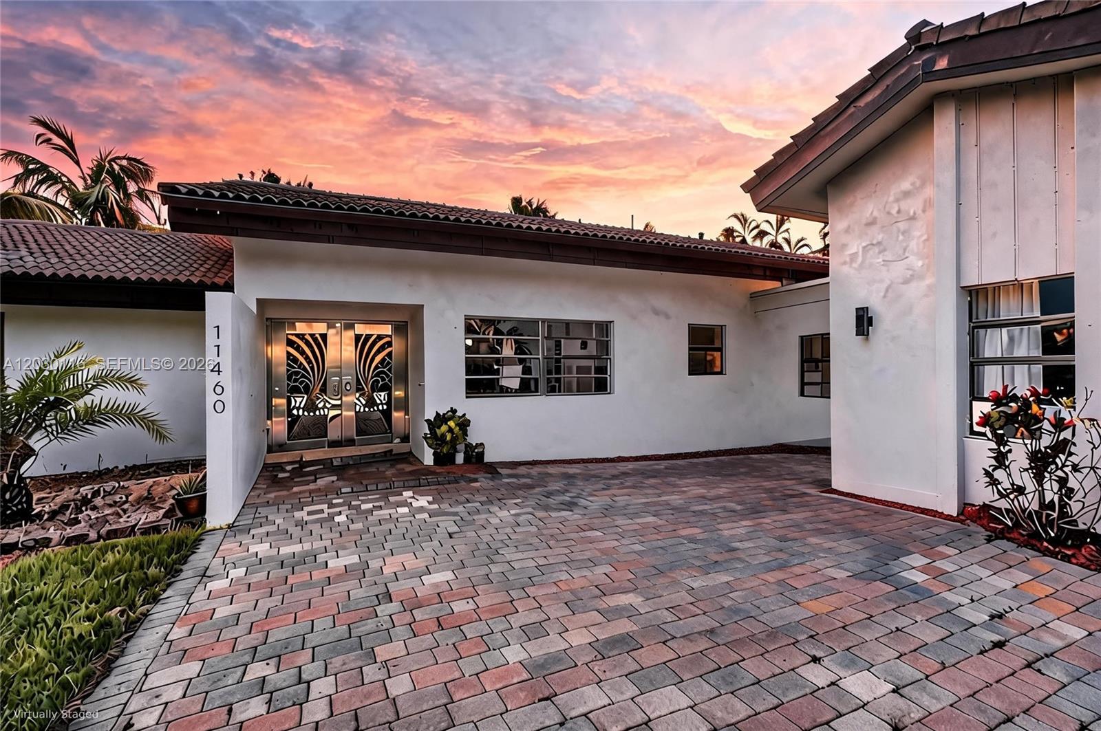 The exterior of a white house features a paved driveway and decorative metal double doors — 11460 SW 1st Ct, Plantation FL 33325, PLANTATION, FL
