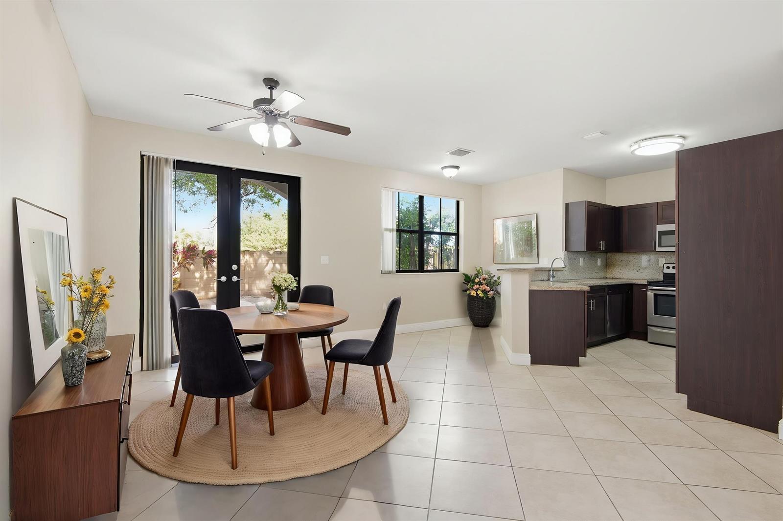 A dining area with a round table and dark chairs sits beside an open kitchen — 3720 SW 69th Avenue # 3720, Miami FL 33155, MIAMI, FL