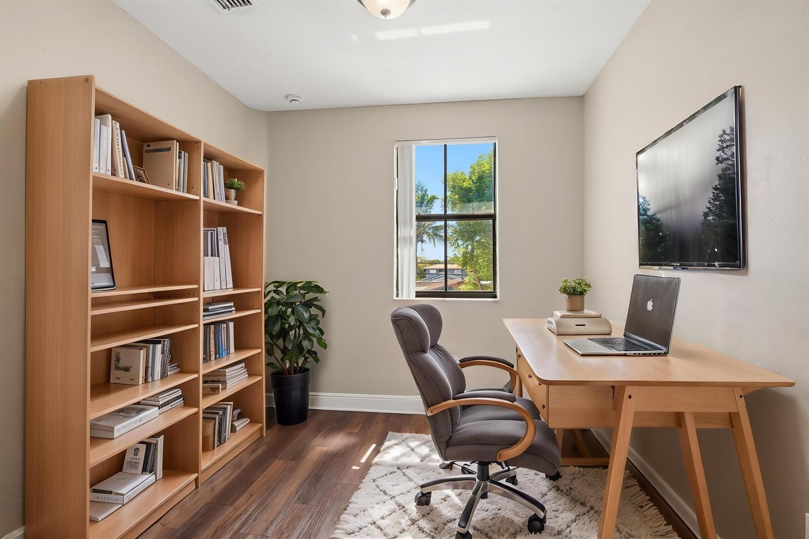 A home office features a wooden desk, a bookshelf, a gray chair, and a window — 3720 SW 69th Avenue # 3720, Miami FL 33155, MIAMI, FL