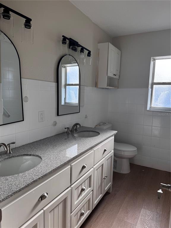 A bathroom features a double vanity with a granite countertop, white cabinets, and tiled walls — 1204 W ALSOBROOK STREET, PLANT CITY, FL