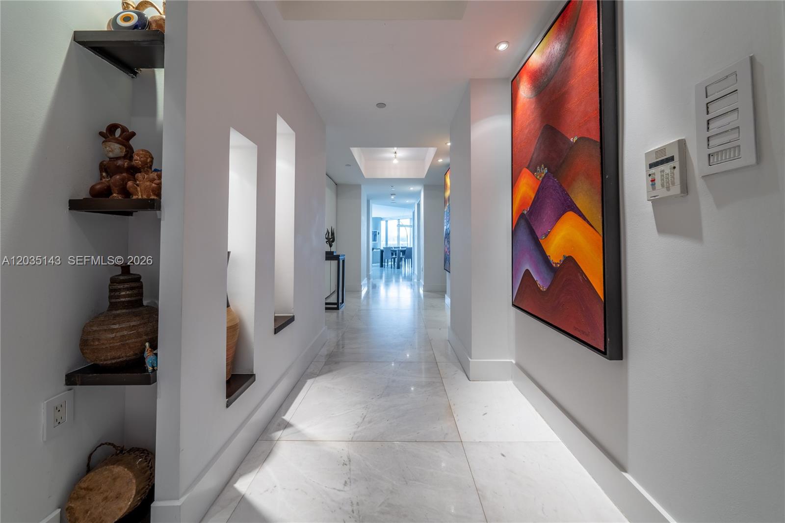A bright hallway features marble floors, recessed wall niches, and a large abstract painting — 9401 Collins Ave # 403, Surfside FL 33154, SURFSIDE, FL