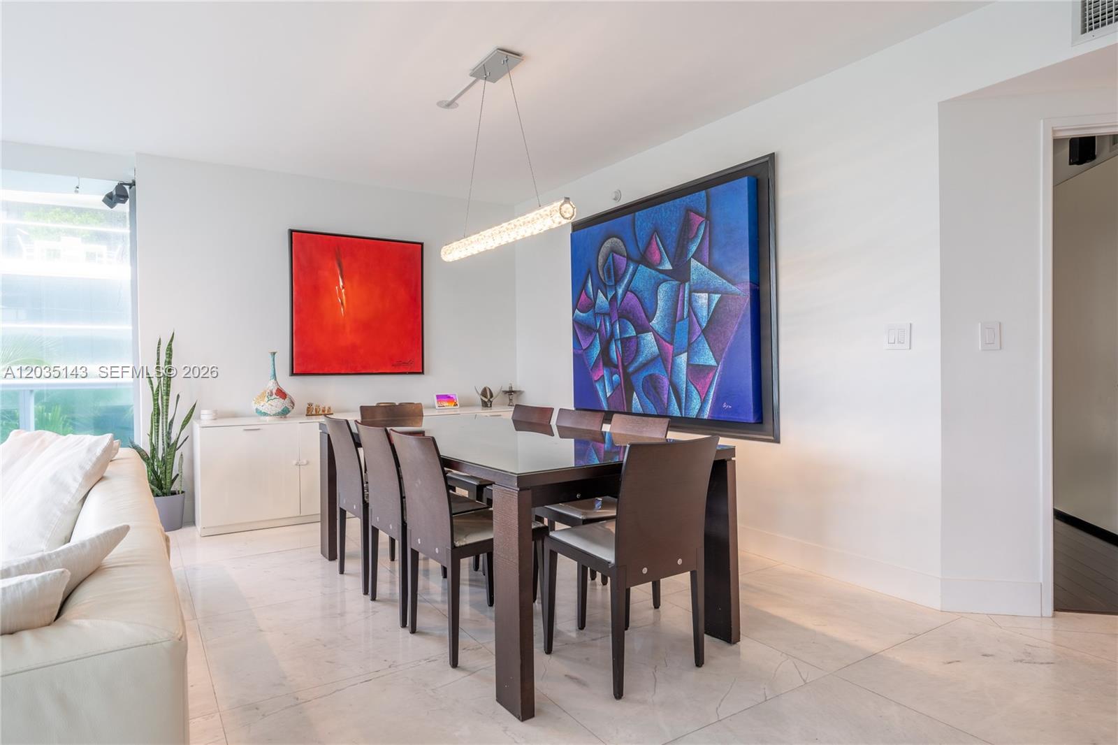 A dining room features a dark wood table, six chairs, and two large abstract paintings — 9401 Collins Ave # 403, Surfside FL 33154, SURFSIDE, FL