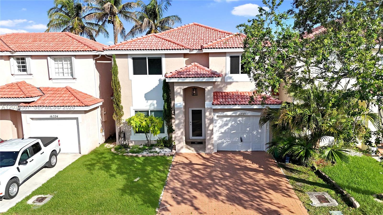A two-story suburban house with a tiled roof, white stucco walls, and a paved driveway — 16330 SW 102nd St, Miami FL 33196, MIAMI, FL