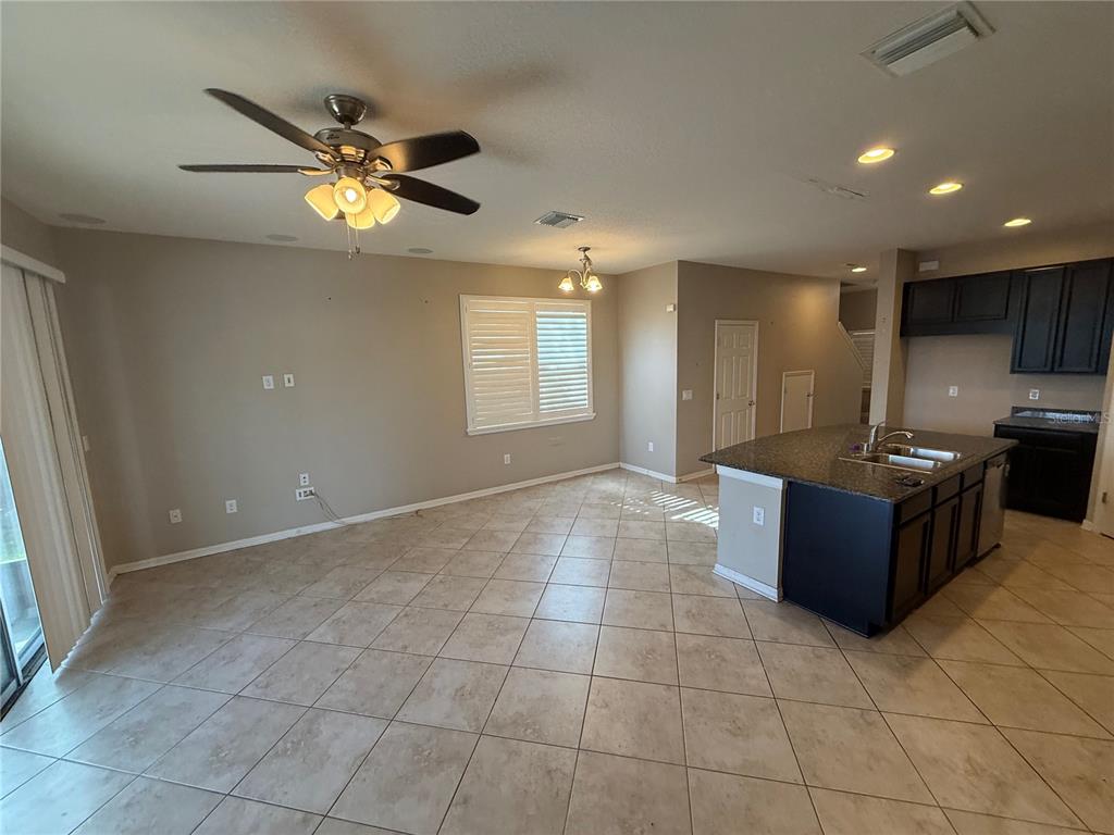 An open-concept kitchen and living area features tile flooring, a ceiling fan, and dark cabinetry — 6629 HOLLY HEATH DRIVE, RIVERVIEW, FL