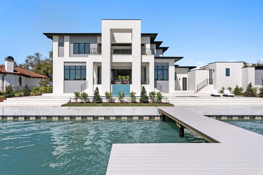 A modern white waterfront house features a multi-level exterior, large windows, and a private dock — 500 BARCELONA DRIVE, TIERRA VERDE, FL