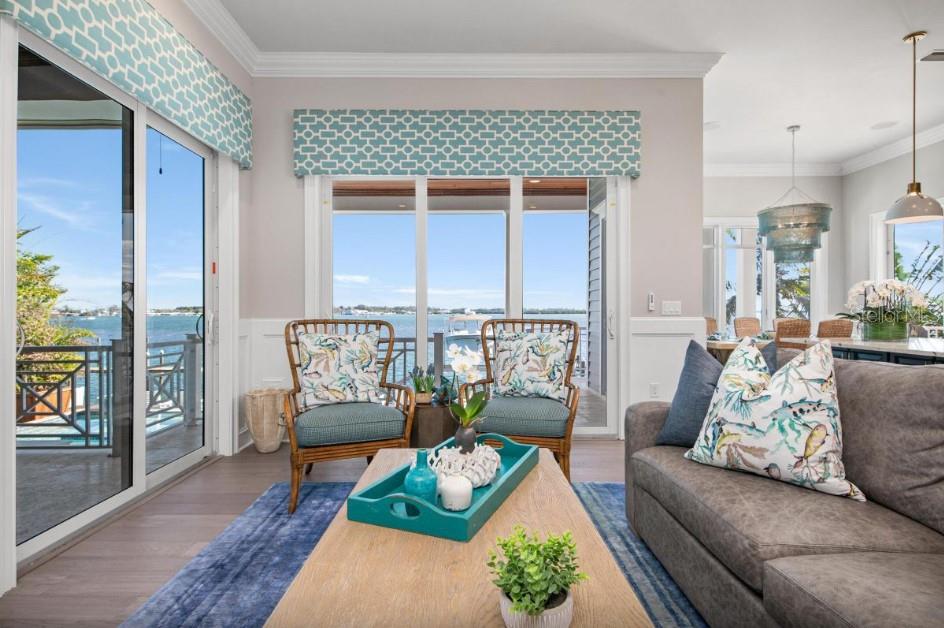 A living room with a water view, two rattan chairs, and a gray sofa — 110 10TH STREET S, BRADENTON BEACH, FL