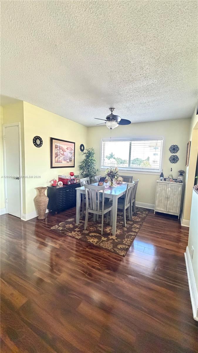 A dining room features a wooden table, six chairs, a rug, and a ceiling fan — 5300 Washington St # D309, Hollywood FL 33021, HOLLYWOOD, FL