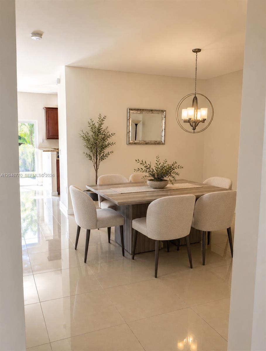 A dining room features a square wooden table, six upholstered chairs, and a modern chandelier — 8820 NW 103rd Ave, Doral FL 33178, DORAL, FL