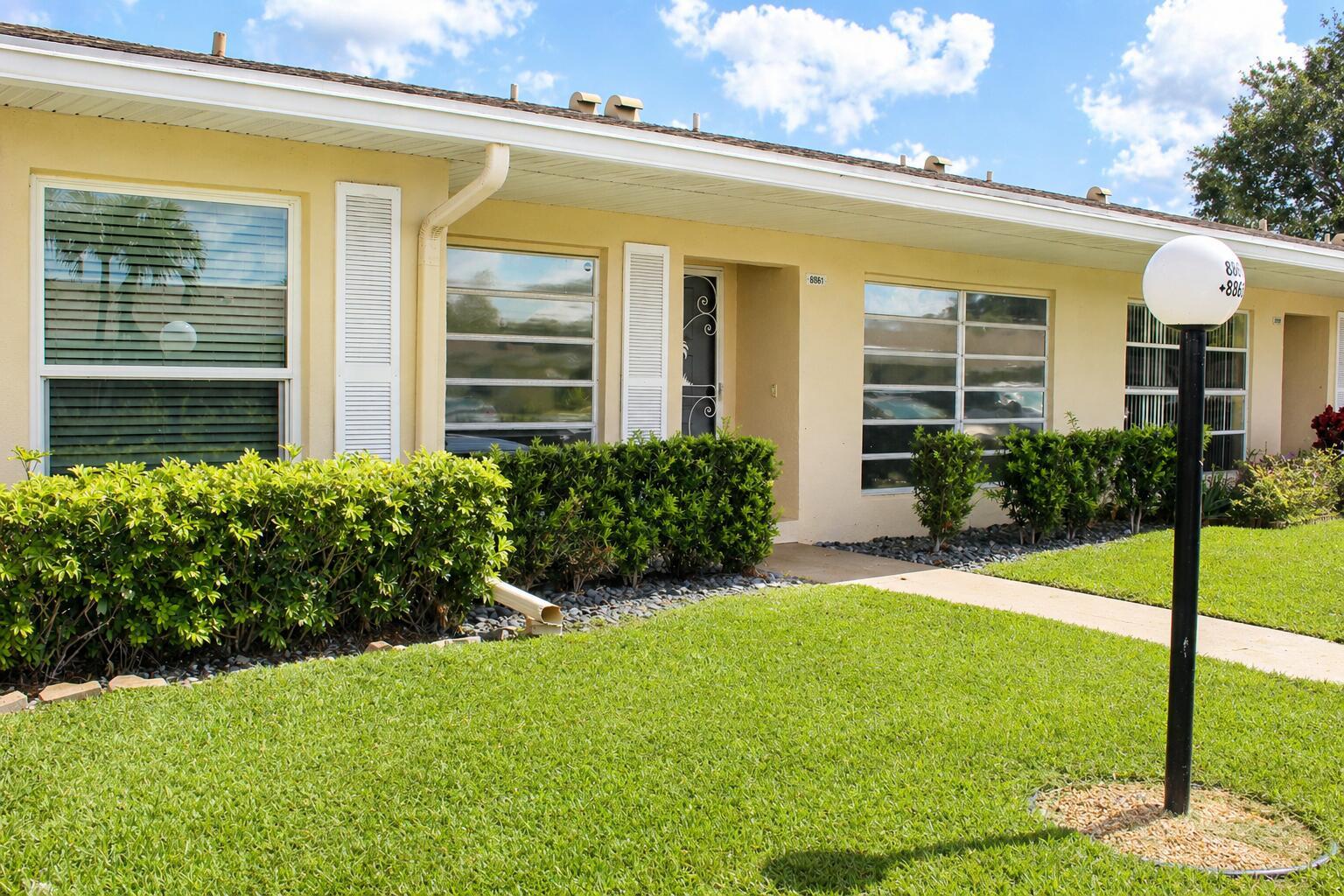 A single-story yellow house with a lawn, landscaping, and a white lamp post — 8861 Bella Vista Drive, Boca Raton FL 33433, BOCA RATON, FL