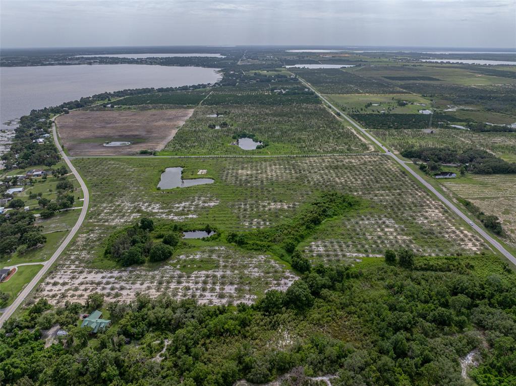 An aerial view shows a large, rural property with citrus groves, ponds, and nearby lakes — 0 LAKE REEDY BOULEVARD, FROSTPROOF, FL