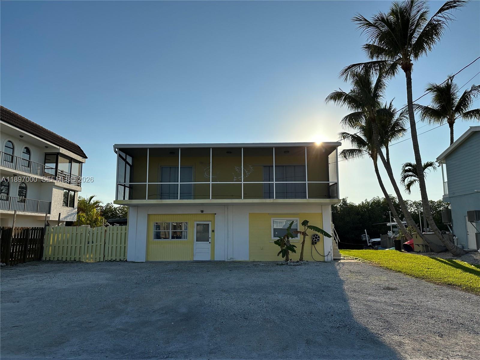 A two-story house with a screened-in upper balcony and a yellow-painted ground floor — 164 Venetian Dr, Islamorada FL 33036, ISLAMORADA, FL