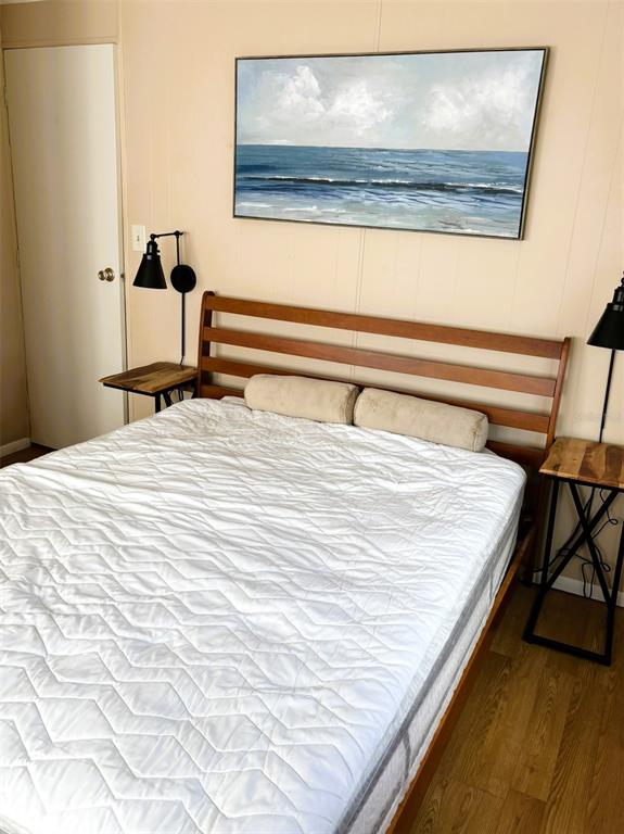 A bedroom features a wooden bed frame, two side tables with lamps, and wall art — 6444 HAELE COURT, NORTH PORT, FL