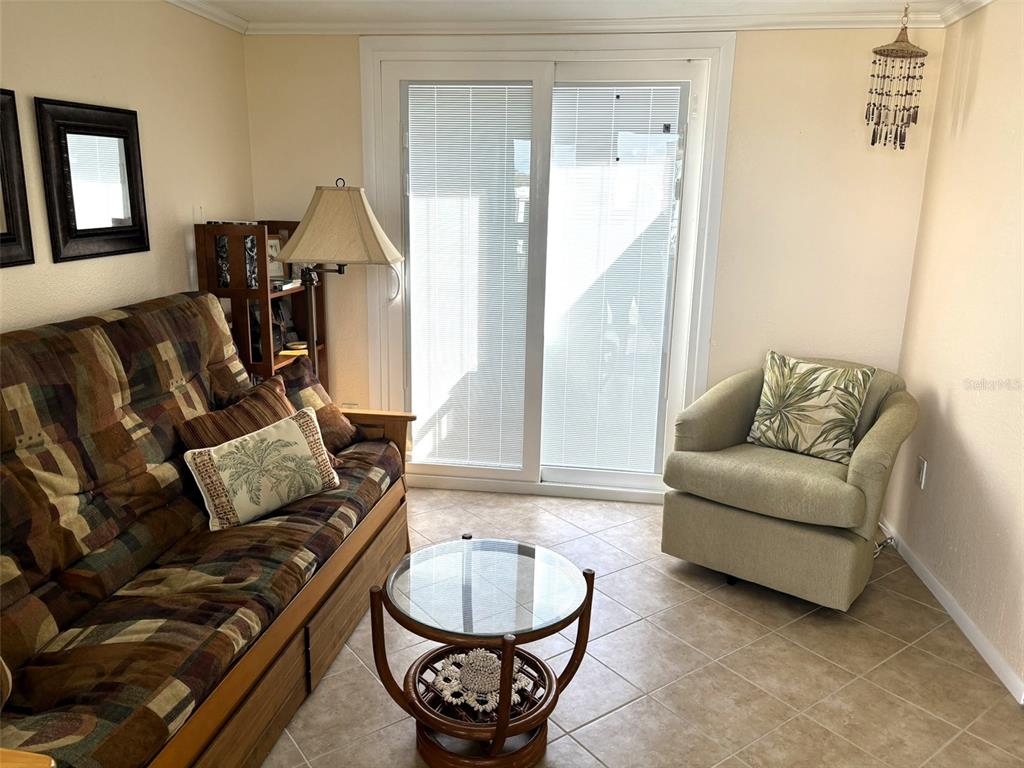 A living room features a patterned sofa, an armchair, a glass coffee table, and sliding doors — 6444 HAELE COURT, NORTH PORT, FL
