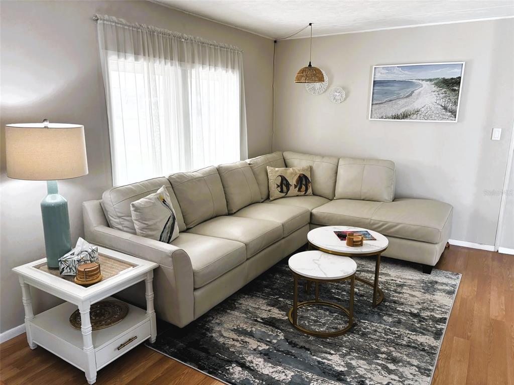 A living room features a beige sectional sofa, a marble-topped nesting table, and a rug — 6444 HAELE COURT, NORTH PORT, FL