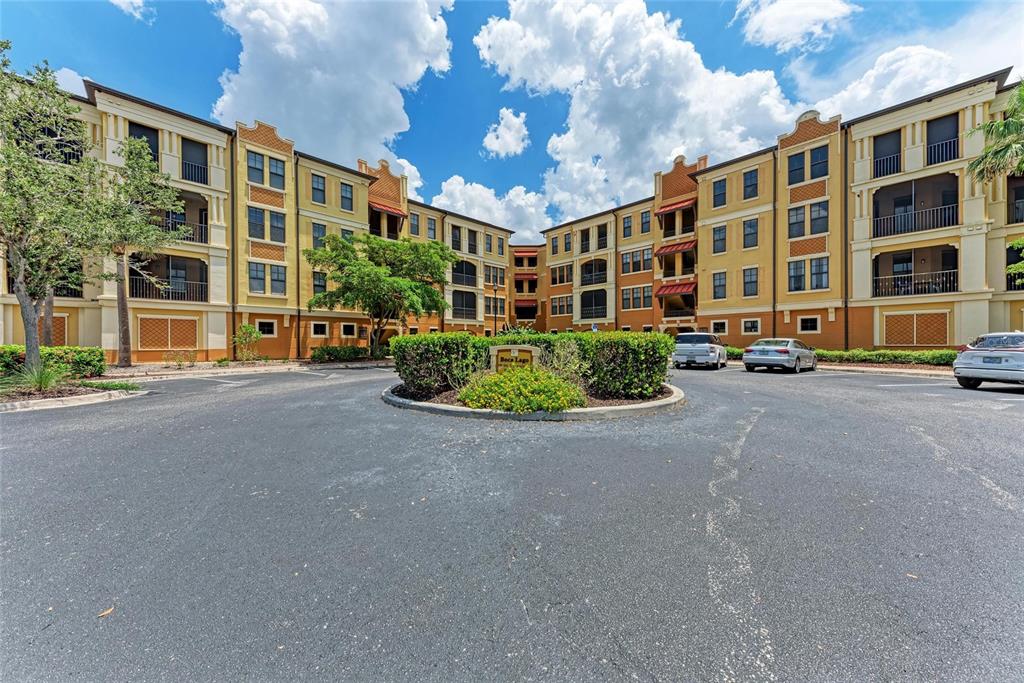 A multi-story apartment building with a central parking lot and landscaped island — 96 VIVANTE BOULEVARD UNIT 210, PUNTA GORDA, FL