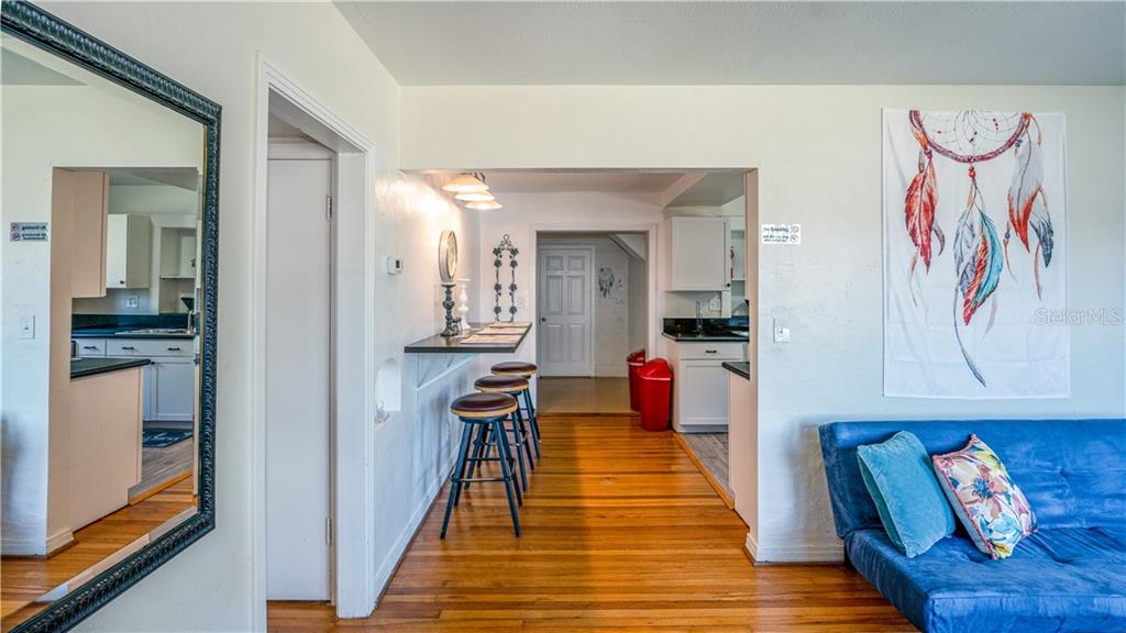A living room with a blue sofa, a breakfast bar, and a view into the kitchen — 2014 NEWMAN STREET, ORLANDO, FL