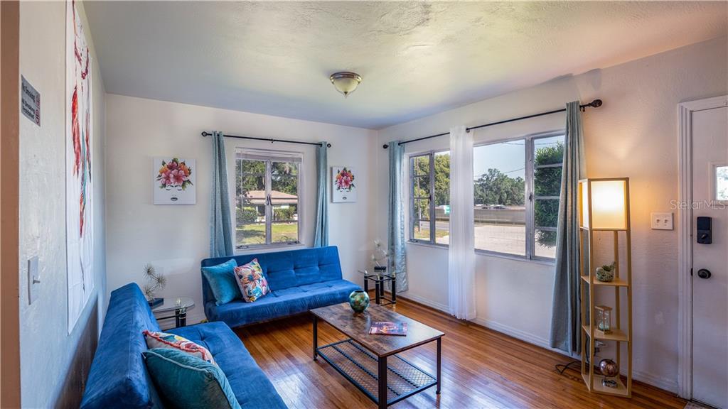 A living room features two blue sofas, a coffee table, and hardwood floors — 2014 NEWMAN STREET, ORLANDO, FL