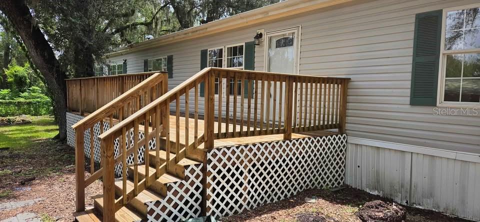 A wooden deck with stairs and lattice skirting is attached to the side of a house — 5301 ROYAL OAK DRIVE, TAMPA, FL