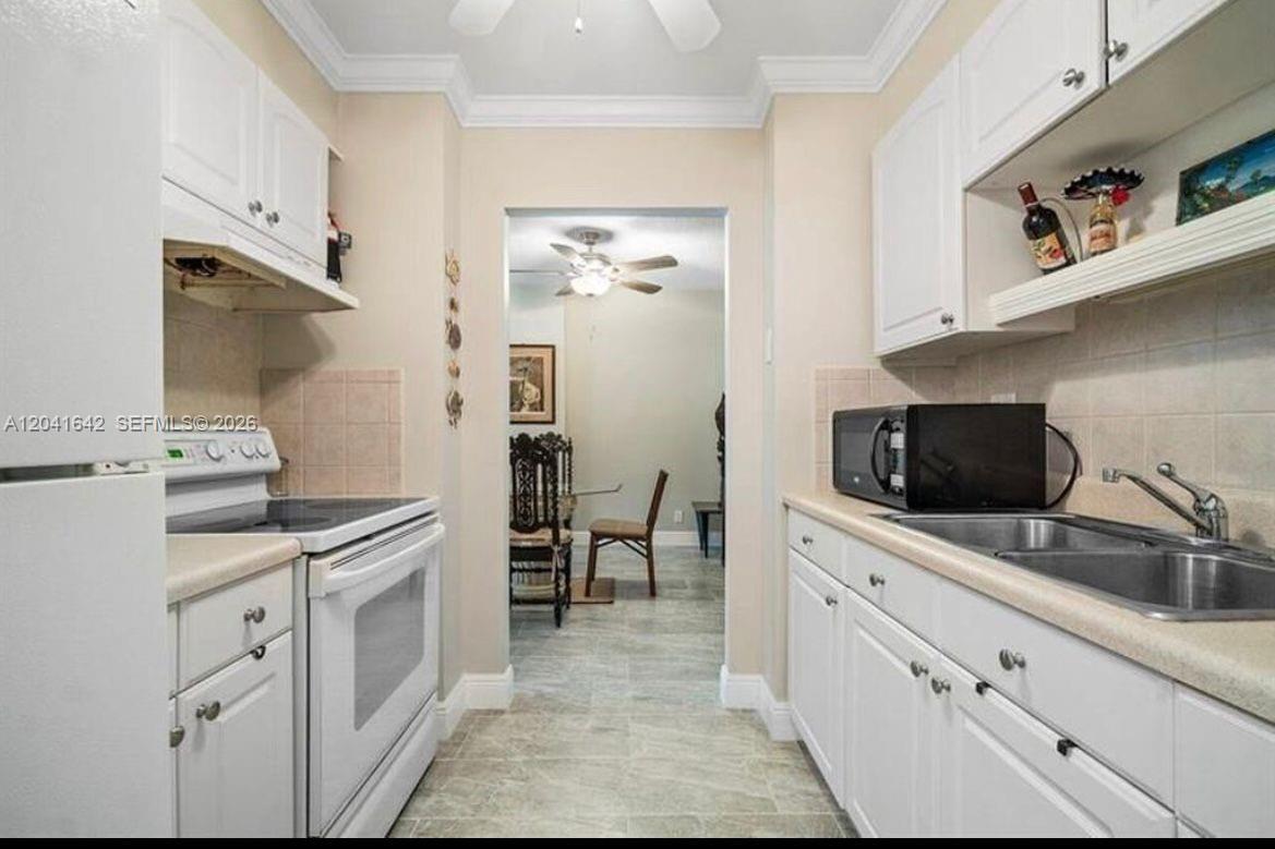 A living room features a large gong, red chairs, a glass coffee table, and ceiling fans — 250 NE 20th St # 3030, Boca Raton FL 33431, BOCA RATON, FL