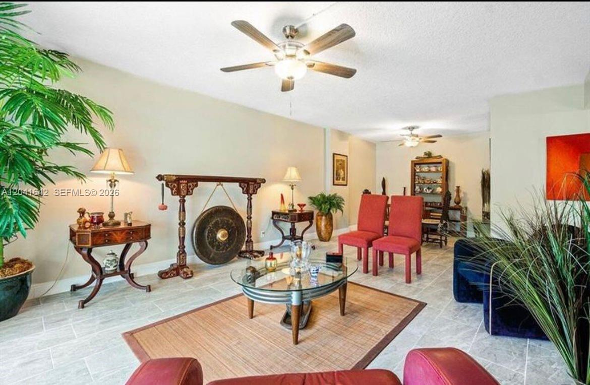 A dining room features a glass-topped table, wooden chairs, a tall bookshelf, and tile flooring — 250 NE 20th St # 3030, Boca Raton FL 33431, BOCA RATON, FL