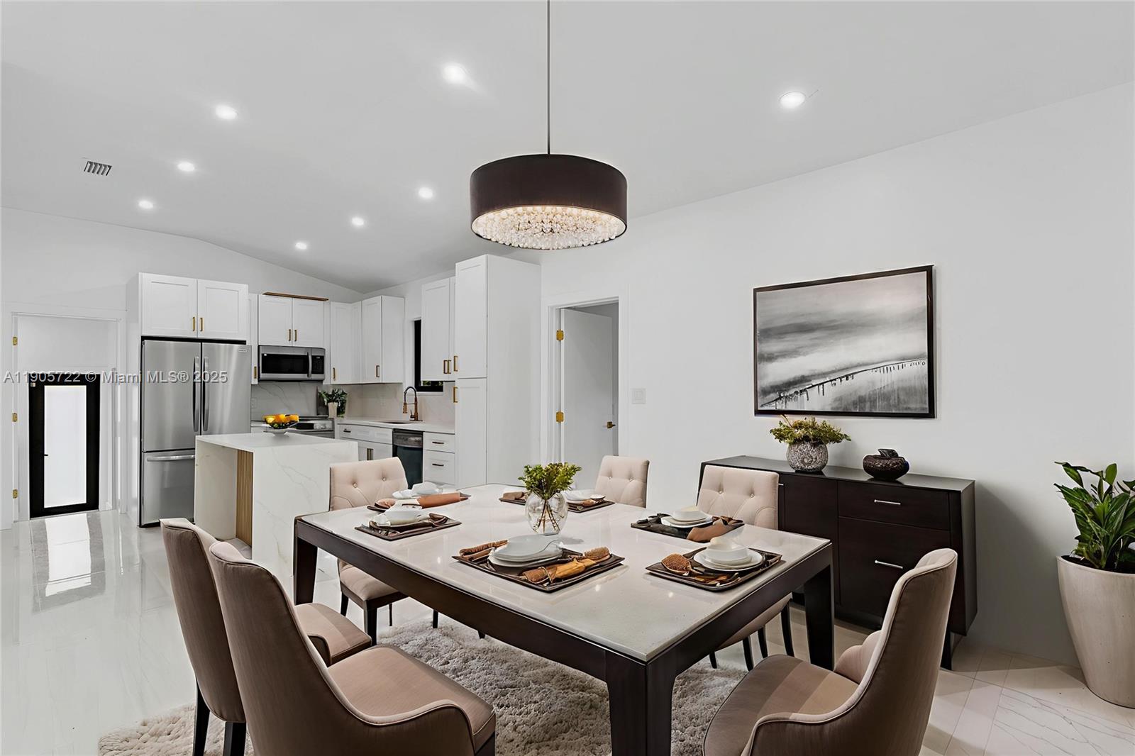 A dining area with a modern table and chairs sits adjacent to a white kitchen — 8635 N Miami Ave, Miami FL 33150, MIAMI, FL