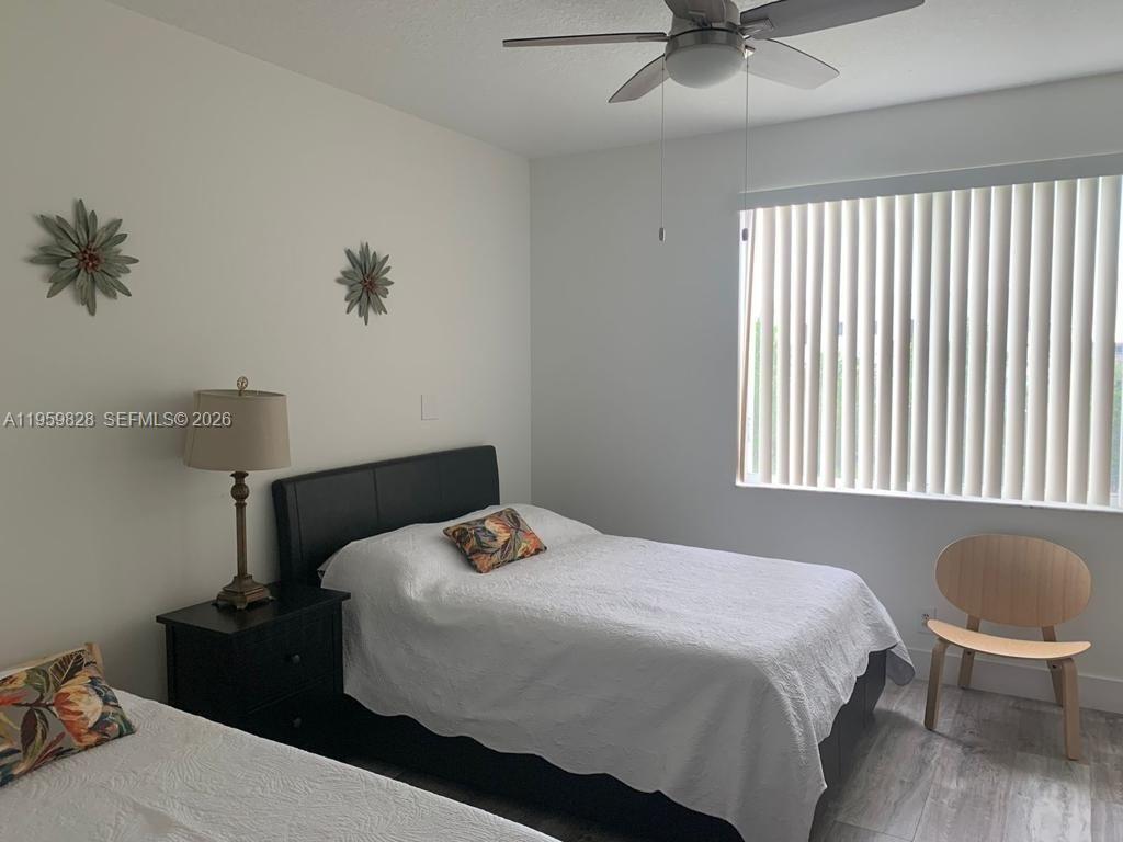 A bedroom features two beds, a nightstand with a lamp, and a window with blinds — 20 Key West Ct, Weston FL 33326, WESTON, FL
