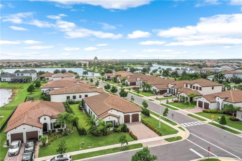 An aerial view shows a suburban neighborhood with houses, a lake, and paved streets — 4761 ROSETTA TER, Ave Maria FL 34142, AVE MARIA, FL