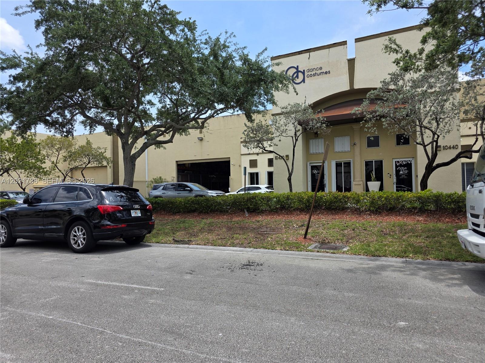 A black SUV is parked in front of a commercial building with a dance costume sign — 10420 NW 37th Ter, Doral FL 33178, DORAL, FL